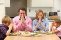 Family saying grace before meal