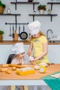 Two cute little sisters happily baking cookies and buns Royalty Free Stock Photo