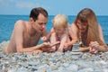 Family on sea coast and pyramid of stones Royalty Free Stock Photo