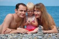 Family on sea coast and pyramid of stones Royalty Free Stock Photo