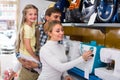 Family selecting sewing machine in store