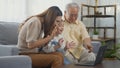 Family senior grandfather, daughter and granddaughter talking online via video chat using laptop computer Royalty Free Stock Photo