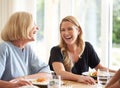 Family With Senior Mother And Adult Daughter Eating Brunch Around Table At Home Together