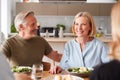 Family With Senior Parents And Adult Offspring Eating Meal Around Table At Home Together Royalty Free Stock Photo