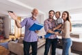Family with senior real-estate agent visiting house for sale
