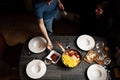 Family sets the table, homemade pasta, bacon, feta and tomatoes, cheeses with blue mold, wine. Deep plates for pasta.