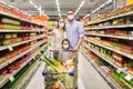 Family with shopping cart in masks at supermarket Royalty Free Stock Photo