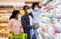 Family shopping during coronavirus pandemic. Black family with child wearing face masks, purchasing food at supermarket