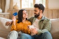 Family shopping online. Cheerful hindu spouses holding cellphone and credit card, using mobile banking application Royalty Free Stock Photo