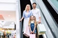 Parents And Daughter Holding Shopping Bags Using Escalator In Mall Royalty Free Stock Photo