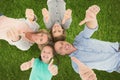 Family showing thumbs up sign while lying on grass Royalty Free Stock Photo