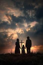 Family silhouette against a sunset sky with a cross.