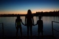 Family silhouette sunset at the lake on vacation Royalty Free Stock Photo