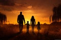Family silhouette walking in a field at sunset, joyful moment