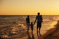 Family silhouettes on beach at sunset Royalty Free Stock Photo