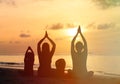 Family silhouettes doing yoga at sunset Royalty Free Stock Photo