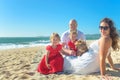 Family with sisters in red dress and dog on the beach Royalty Free Stock Photo