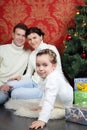 Family sit on floor with gifts near Christmas tree at home Royalty Free Stock Photo