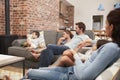 Family Sit On Sofa In Open Plan Lounge Watching Television Royalty Free Stock Photo