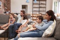 Family Sit On Sofa In Open Plan Lounge Watching Television Royalty Free Stock Photo