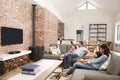 Family Sit On Sofa In Open Plan Lounge Watching Television Royalty Free Stock Photo