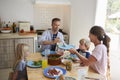 Family sitting around kitchen table serving lunch