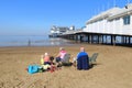 Family sitting on beach by pier