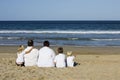 Family sitting on beach watching ocean Royalty Free Stock Photo