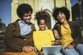 Family sitting on bench, relaxing using digital tablet, shopping online