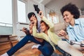 Family sitting on the couch together playing video games, selective focus Royalty Free Stock Photo