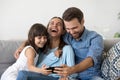 Family sitting on couch using smartphone watching video laughing Royalty Free Stock Photo