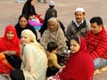 Family sitting in a courtyard of Jama Masjid, Delhi