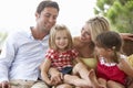 Family Sitting On Garden Seat Together Royalty Free Stock Photo