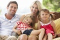 Family Sitting On Garden Seat Together Royalty Free Stock Photo