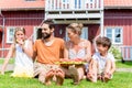 Family sitting in grass front of home eating water melon Royalty Free Stock Photo