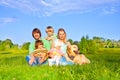 Family sitting on green grass with dog Royalty Free Stock Photo