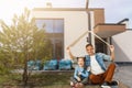 Family sitting on lawn in backyard, big modern house on background Royalty Free Stock Photo