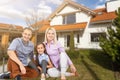 Family sitting on lawn in backyard, big modern house on background Royalty Free Stock Photo