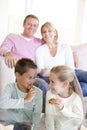 Family sitting in living room eating cookies