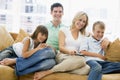 Family sitting in living room with remote control Royalty Free Stock Photo