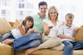 Family sitting in living room with remote control Royalty Free Stock Photo