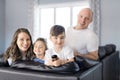 Family sitting in living room with remote control smiling Royalty Free Stock Photo