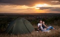 Family sitting near camp tent on the hill Royalty Free Stock Photo