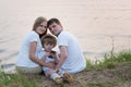Family sitting near the lake on nature in summer Royalty Free Stock Photo