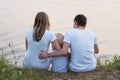 Family sitting near the lake on nature in summer Royalty Free Stock Photo