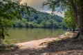 A family sitting on a park bench along the silky brown water of the Chattahoochee river surrounded by lush green trees Royalty Free Stock Photo