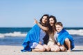 Family sitting on a beach, older sister pointing her finger Royalty Free Stock Photo