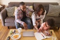 Family Sitting On Sofa As Daughter Colors In Picture Book Royalty Free Stock Photo