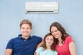 Family Sitting On Sofa Under Air Conditioning Royalty Free Stock Photo