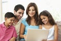 Family Sitting On Sofa At Home With Laptop Royalty Free Stock Photo